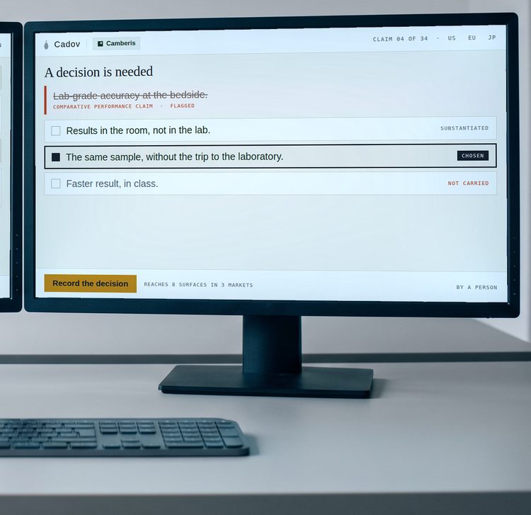 Two monitors on a plain desk. The left screen carries the exchange that produced three ways to say a flagged claim; the right screen carries the three options with one chosen.